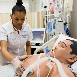 Nursing student using stethoscope on mannequin chest